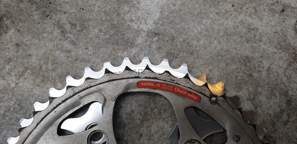 New chainring next to a worn chainring