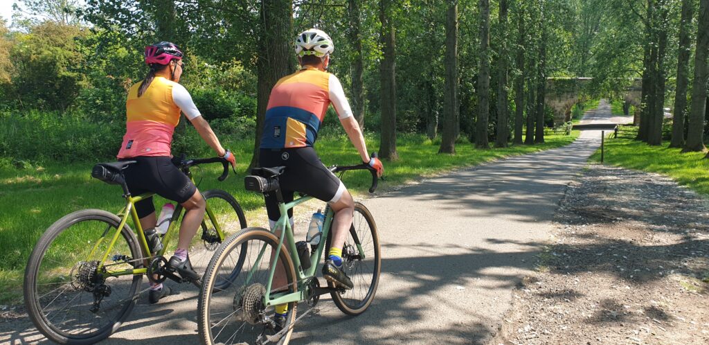 Two cyclists on their bikes on a quiet country lane in the summer time.